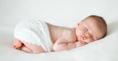 A peaceful newborn baby sleeping, illustrating the calm of healthy infant sleep.